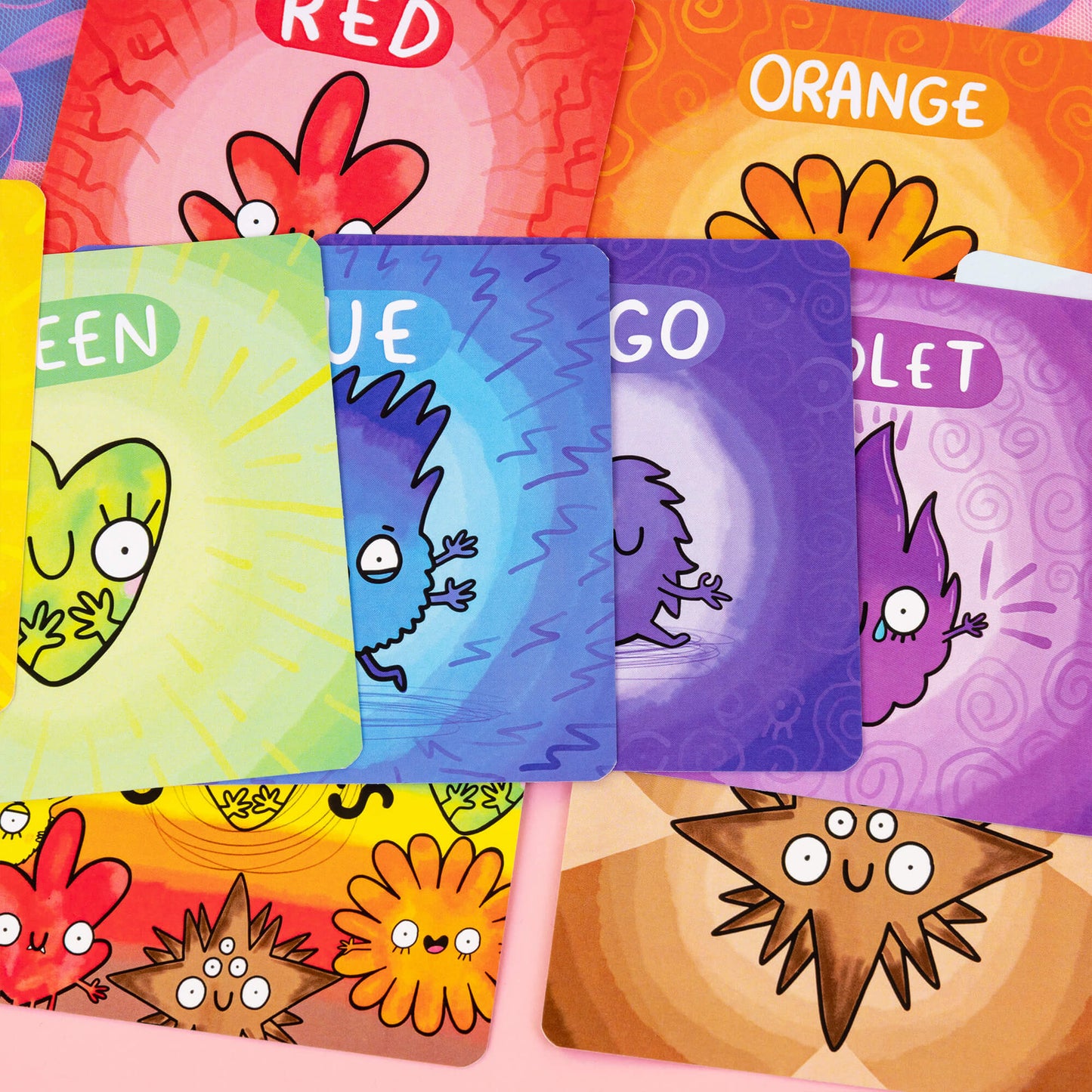 Spread of colourful Chakreatures cards by Happiness Enchanters, featuring unique characters representing colours and elements such as red, orange, yellow, and earth. Each creature is designed with an expressive face and playful charm, embodying different energy centres. Perfect for exploring spiritual connection and self-awareness through a fun, artistic approach.