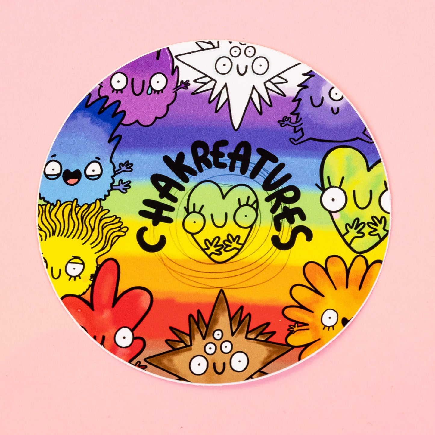 Vibrant sticker by Happiness Enchanters featuring a group of cheerful Chakreatures in rainbow colours, each symbolising different chakras and energies. Characters like red, yellow, green, and violet figures stand against a rainbow background