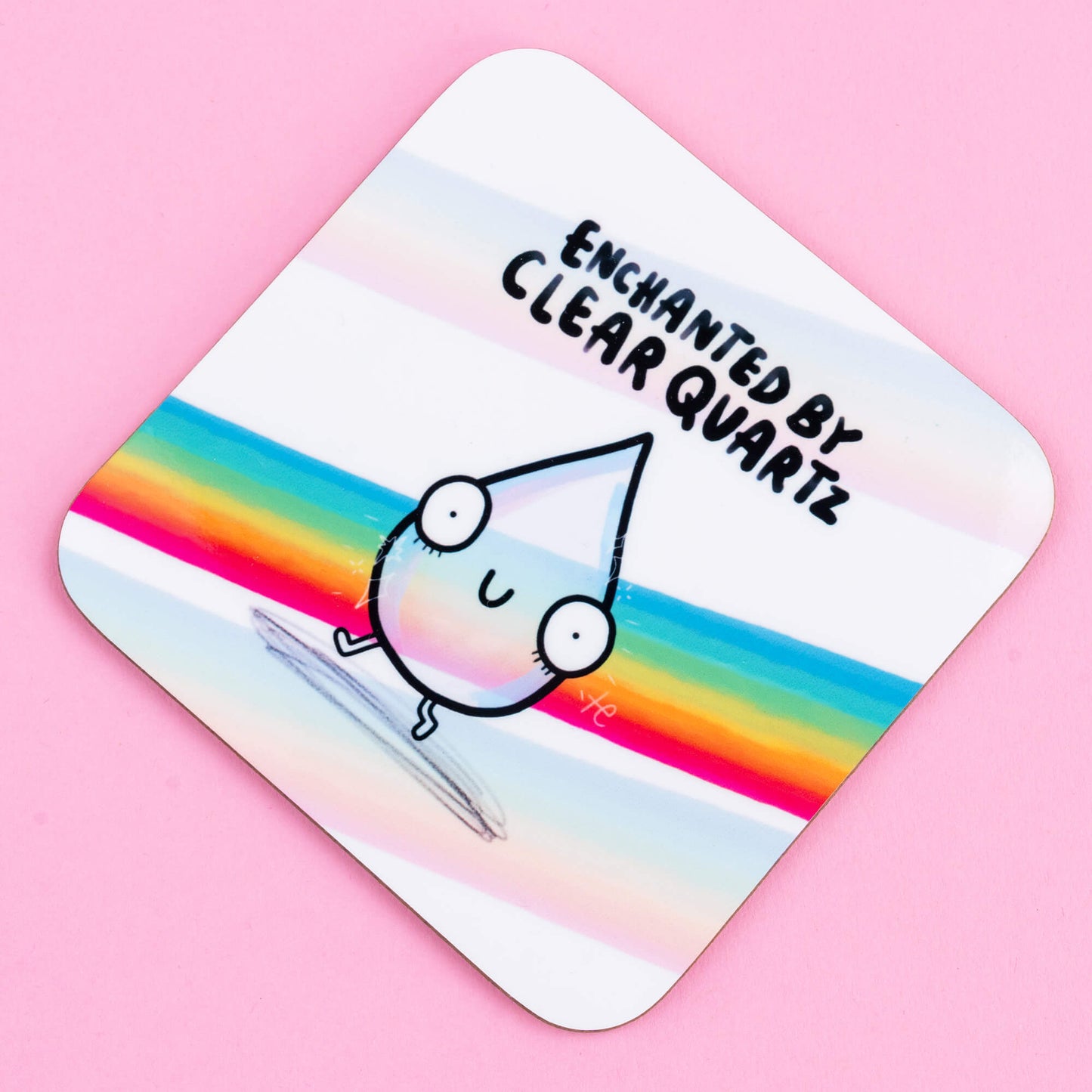 Close-up of a Happiness Enchanters coaster depicting a charming teardrop character with big eyes and a happy expression, surrounded by rainbow stripes, with the phrase 'Enchanted by Clear Quartz.' A playful, enchanting illustration for positive energy.