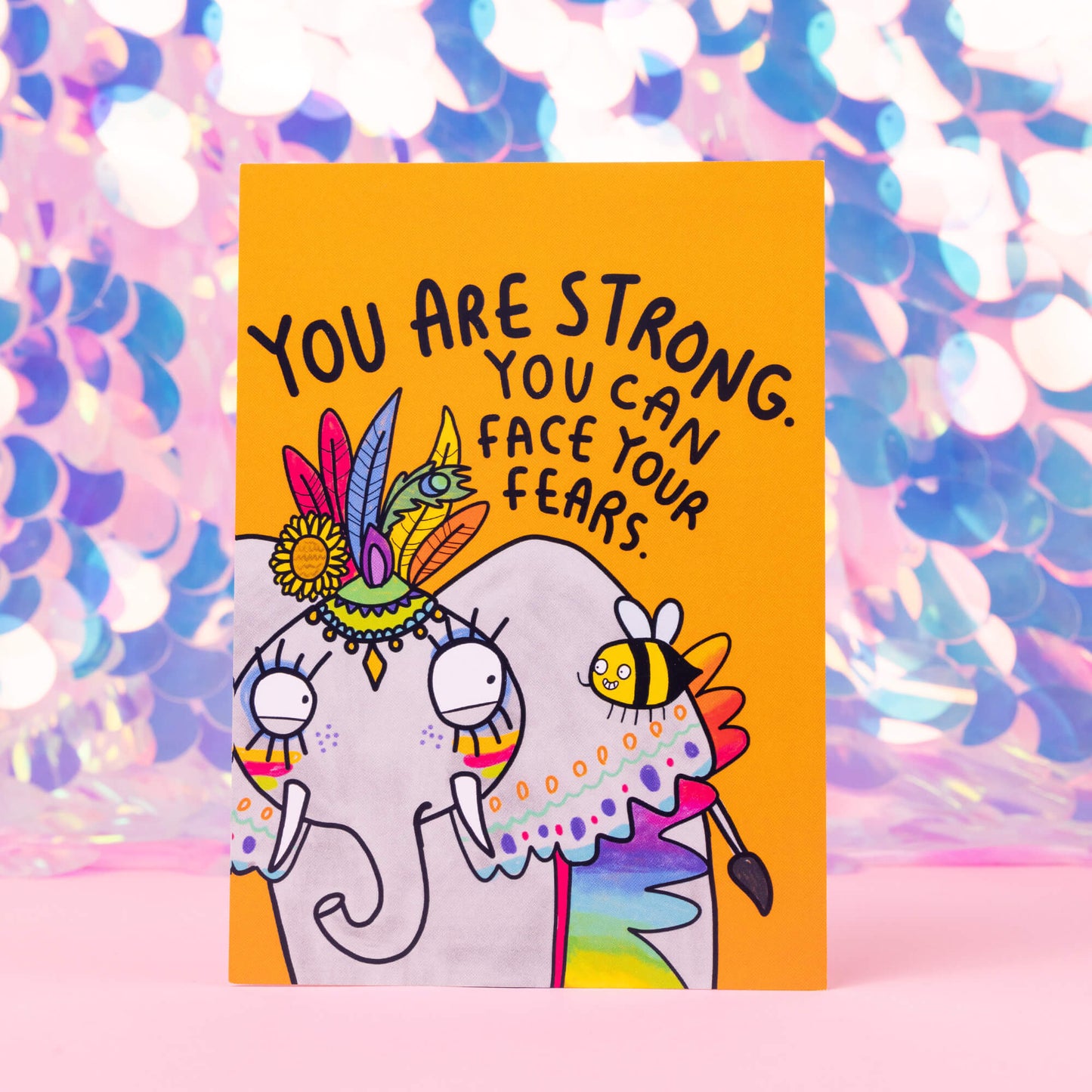 Face Your Fears Postcard. Listen to the Bee! You are strong. You CAN face your fears. Postcard illustrated by Katie Abey of an elephant with rainbow makeup and a bee whispering in its ear