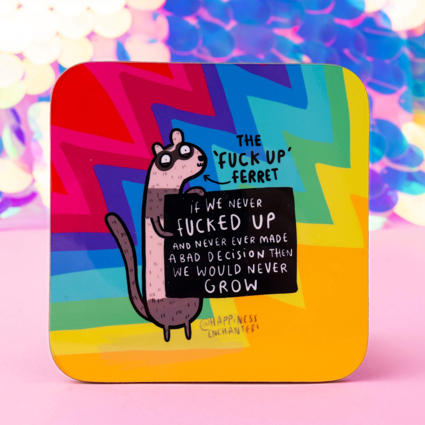 A colourful coaster featuring "The 'Fuck Up' Ferret" by Happiness Enchanters, with a humorous illustration of a quirky ferret holding a sign that reads, "If we never fucked up and never ever made a bad decision, then we would never grow." The background showcases vibrant zigzag patterns in red, blue, green, and yellow hues.