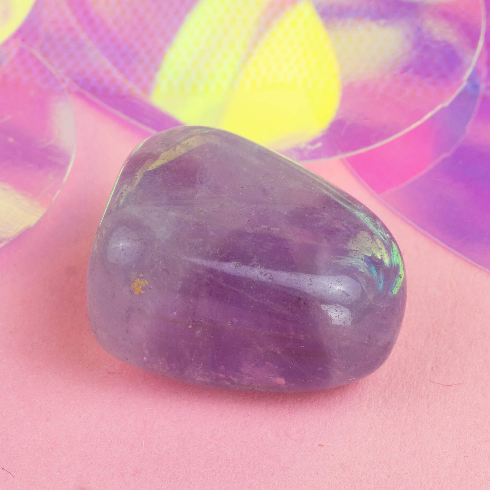 Happiness Enchanters amethyst crystal on a pink holographic backdrop