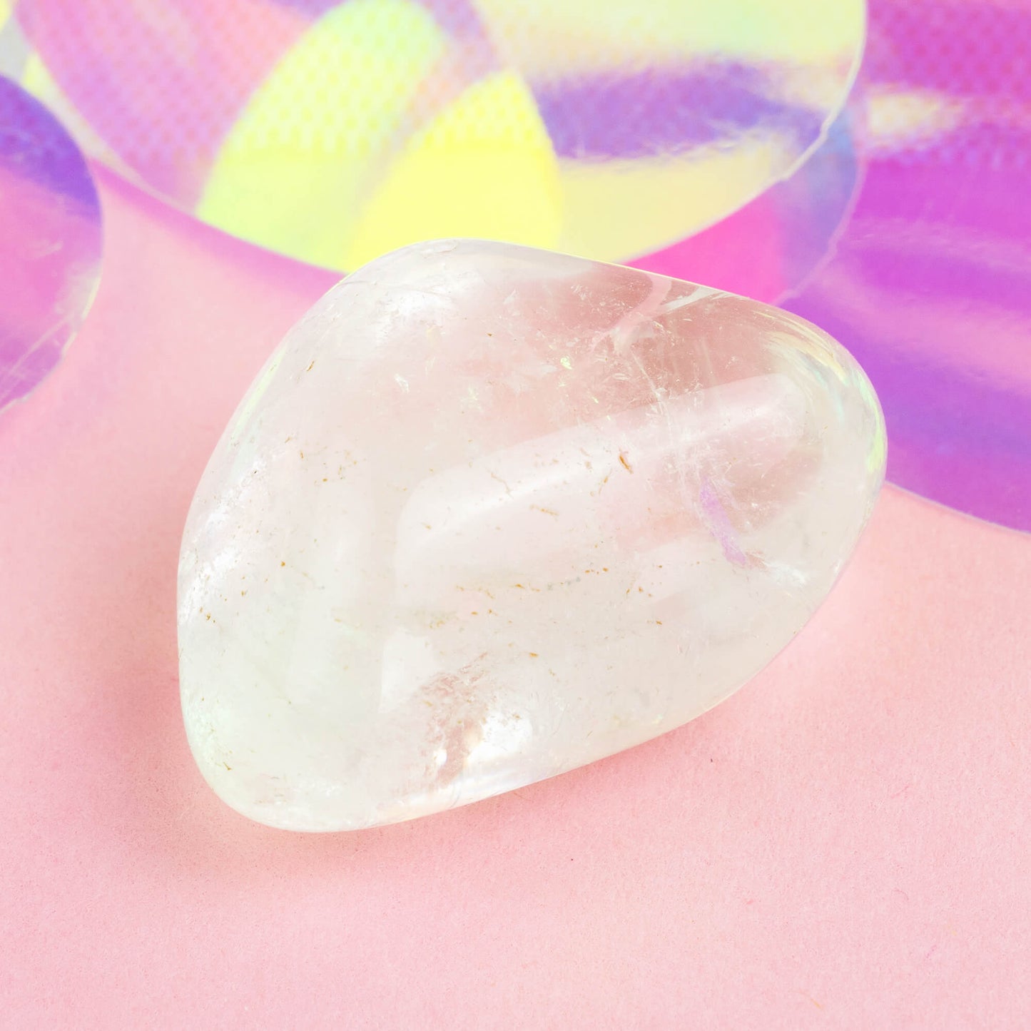 Happiness Enchanters clear quartz crystal on a pink holographic backdrop