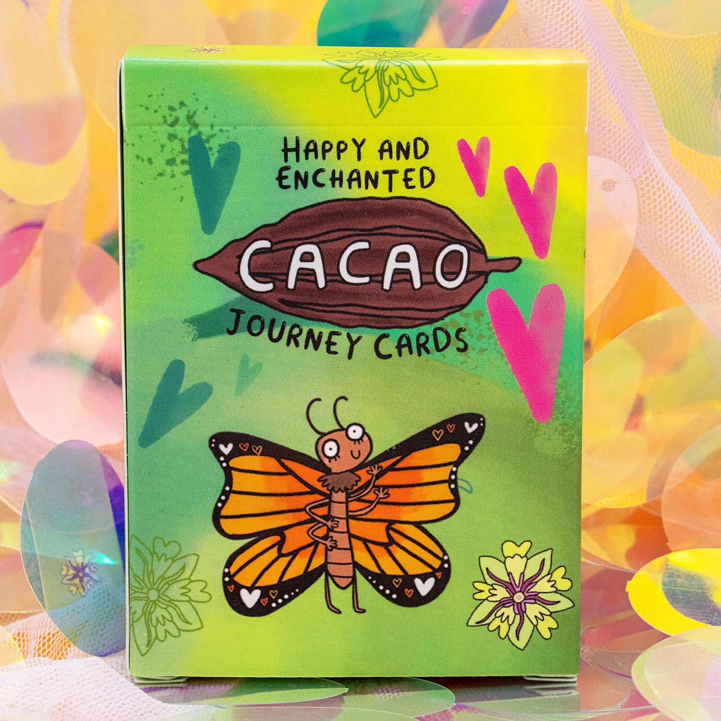 Front of the Cacao Journey Cards box by Happiness Enchanters, featuring a bold cacao pod illustration, hearts and a butterfly. Designed by Katie Abey and Angela Sandland for cacao rituals, mindfulness and plant spirit connection.
