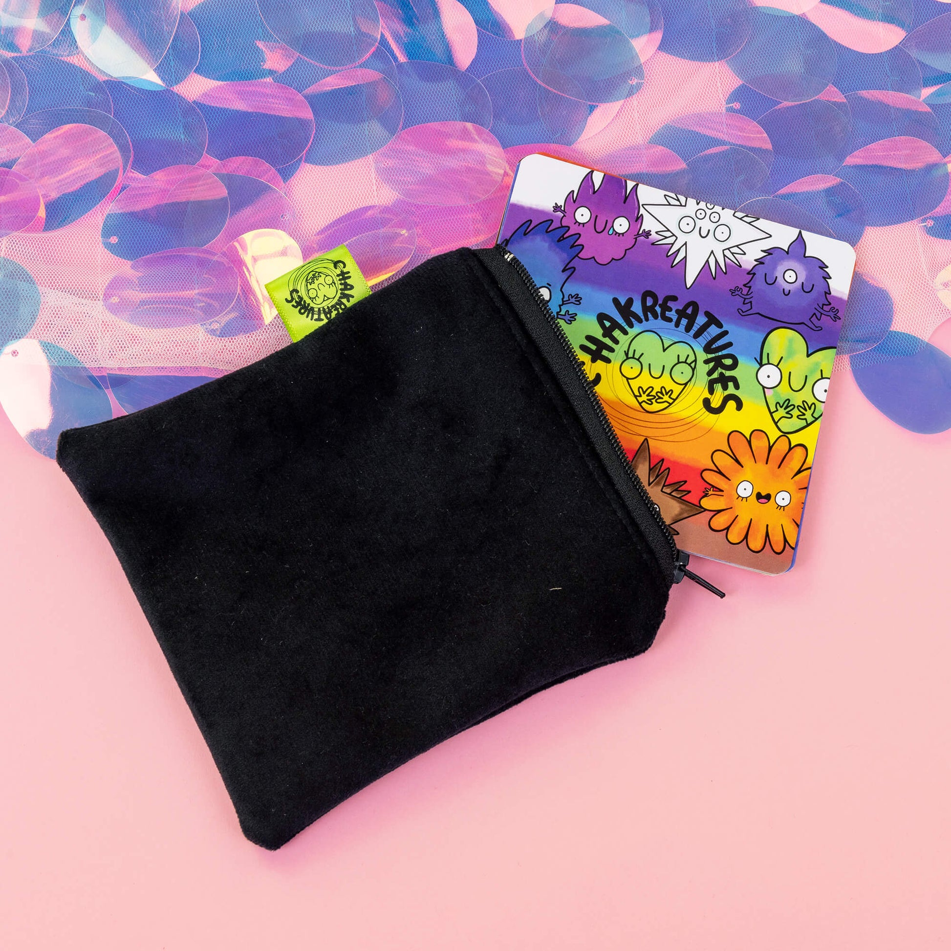 Black velvet pouch partially open with colourful Chakreatures cards by Happiness Enchanters peeking out.