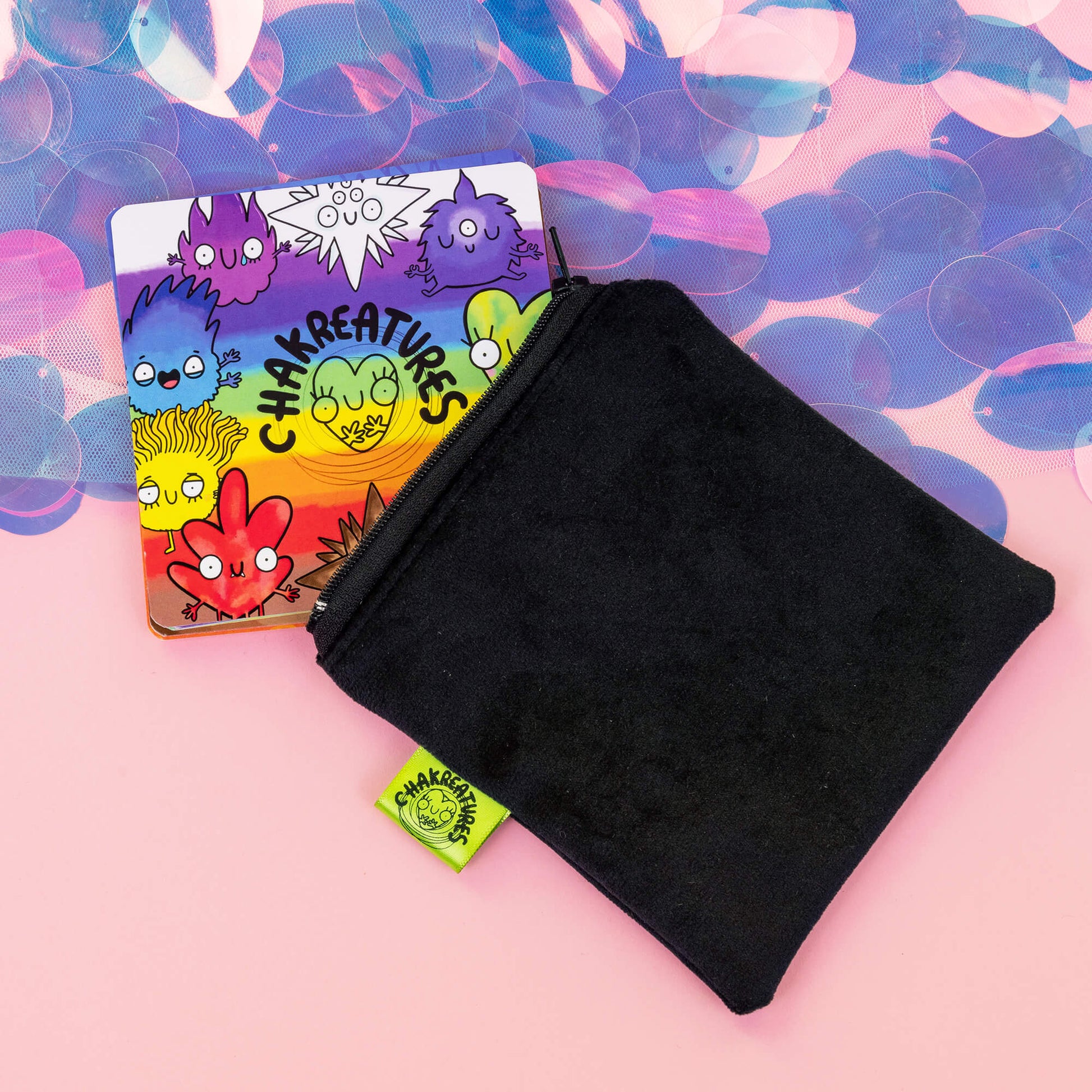 Black velvet pouch partially open with colourful Chakreatures cards by Happiness Enchanters peeking out.