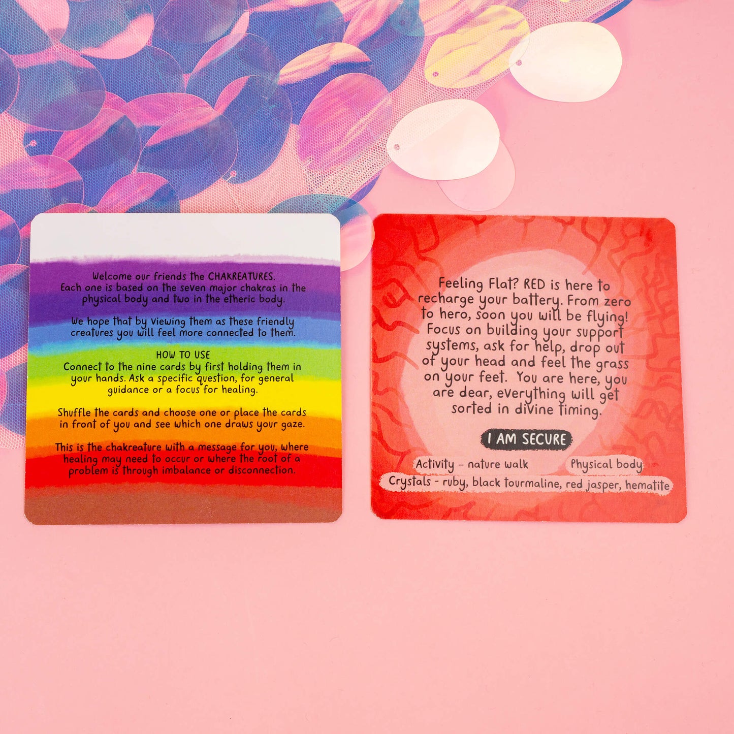 Two Chakreatures cards on a pink background. The rainbow card introduces Chakreatures and instructions, while the red chakra card offers grounding advice, like focusing on support systems and nature walks, with crystals such as ruby and black tourmaline to aid in security.