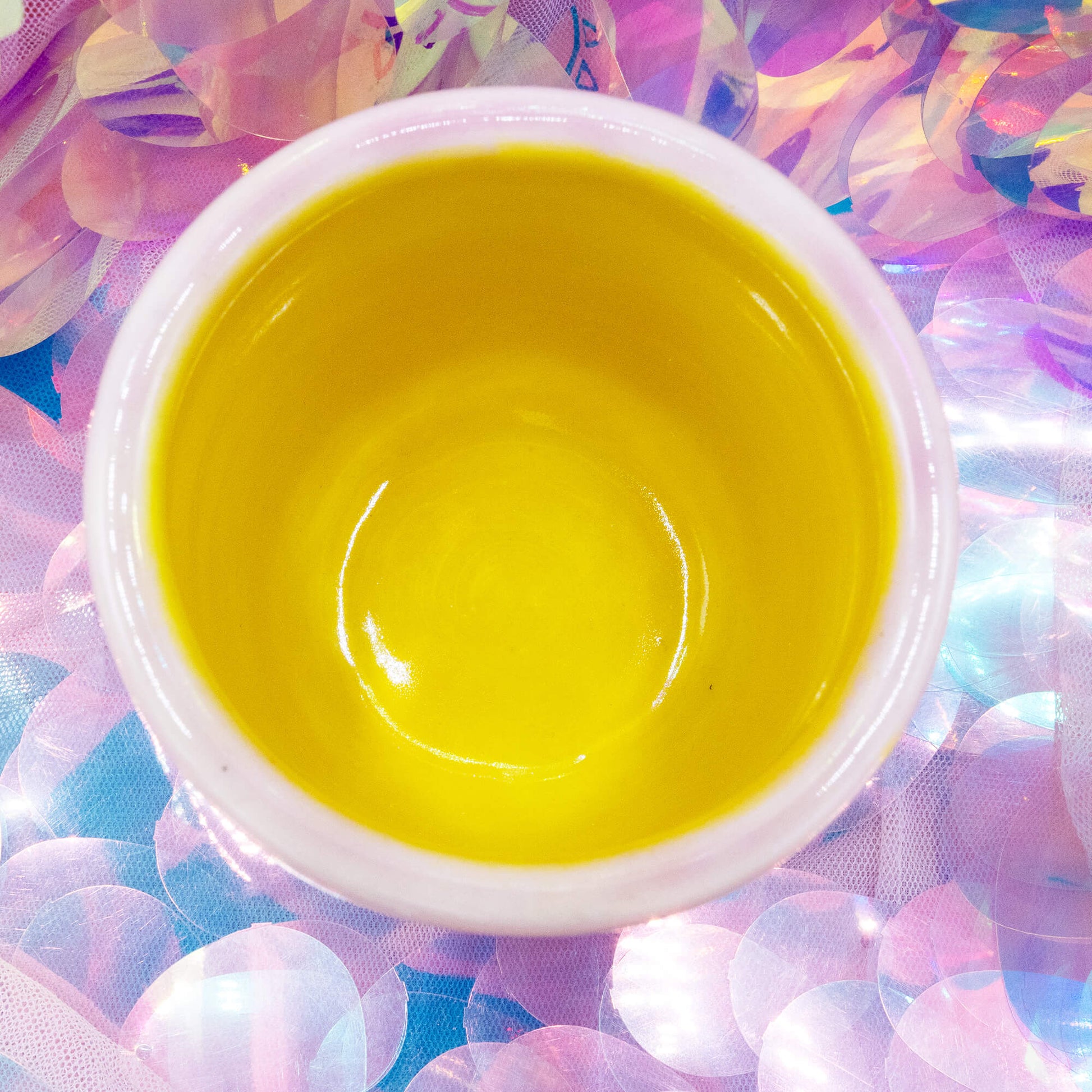 Overhead view of a pink handmade Happiness Enchanters cacao cup with bright yellow interior.