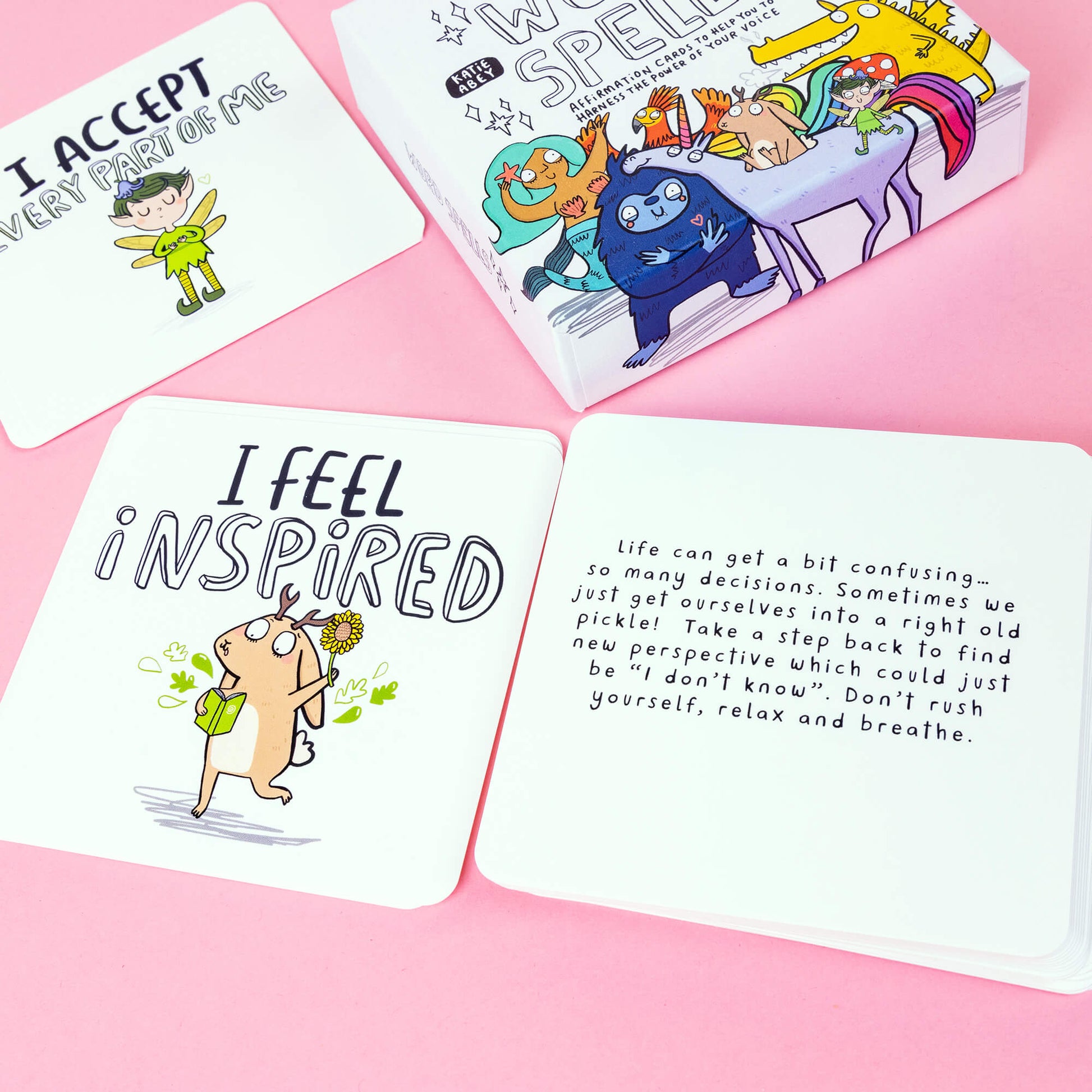 Box of Word Spell Cards on a pink and sparkly background, the box is white with 'your words carry energy' and 'affirmation cards to help you to harness the power of your voice' written on with various illustrations.